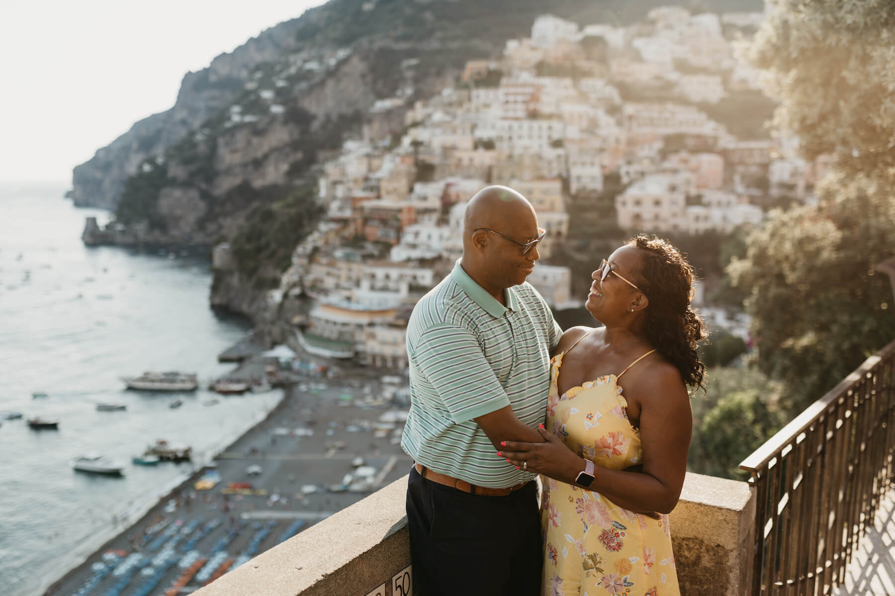 A couple hugging wearing green and yellow in Positano on a couple photoshoot with Flytographer