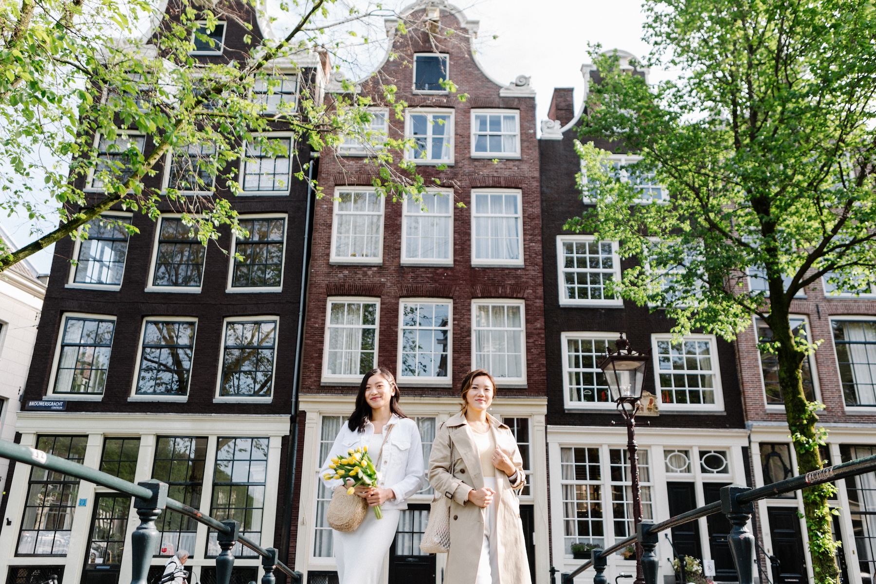 Two friends holding bouquets of flowers on a flytographer photoshoot in Amsterdam