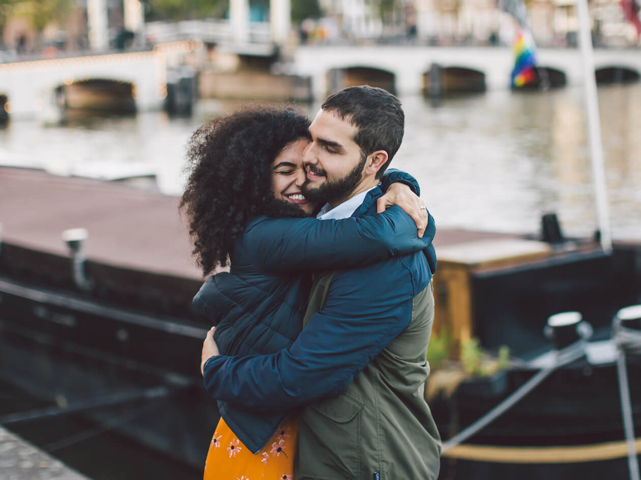 A couple hugging in front of a gondola in Venice