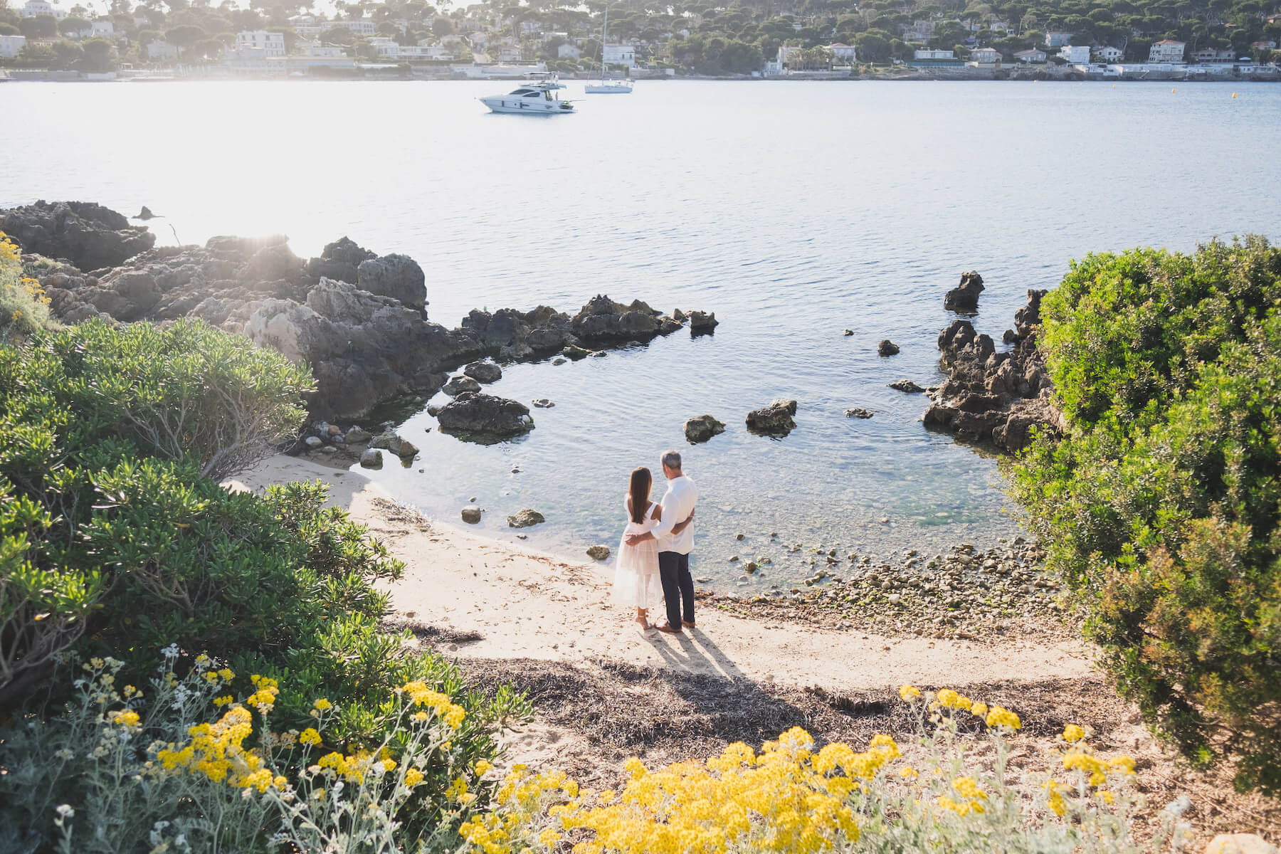 A couple holds hands while looking out at the ocean near Cap d’Antibes on the French Riviera