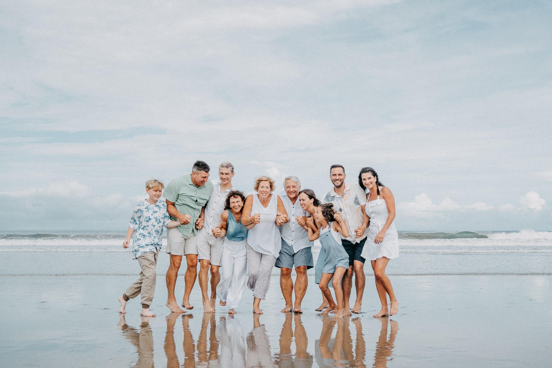 A large group of family and friends hug and smile on the beaches of Guanacaste, Costa Rica