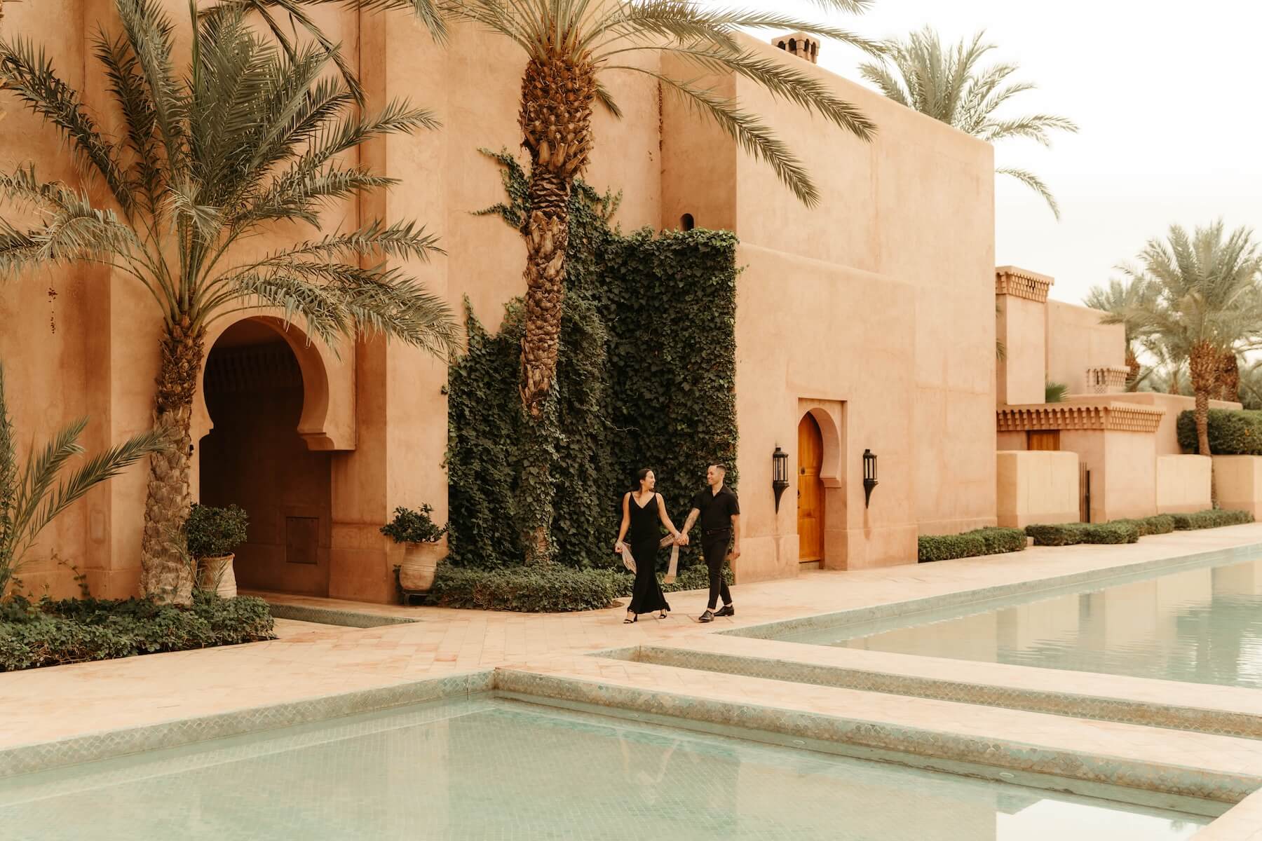 A couple walking at the pool at the Amanjena Resort in Marrakesh.
