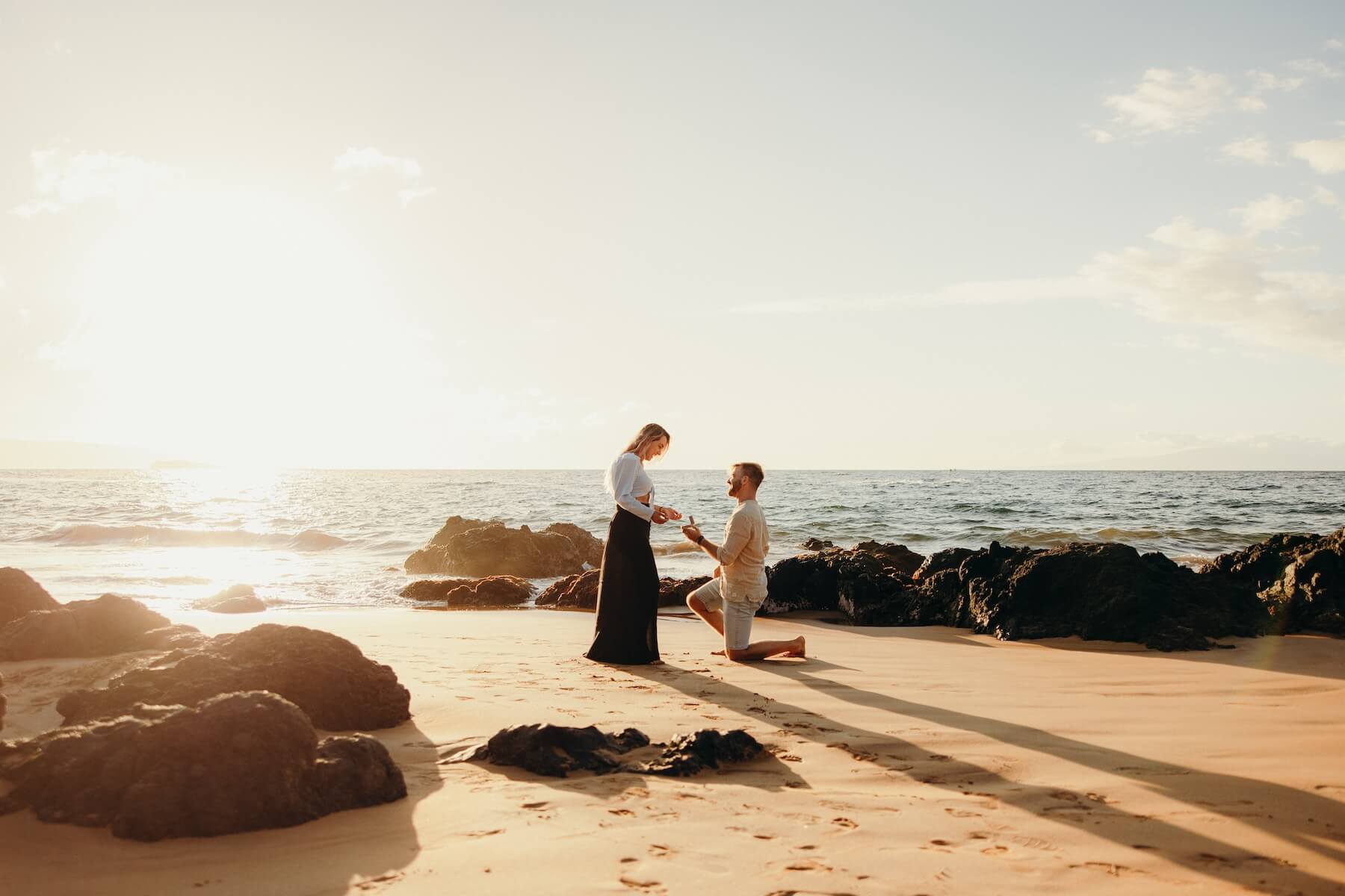A couple getting engaged on the beach in Maui with a proposal photoshoot with Flytographer.