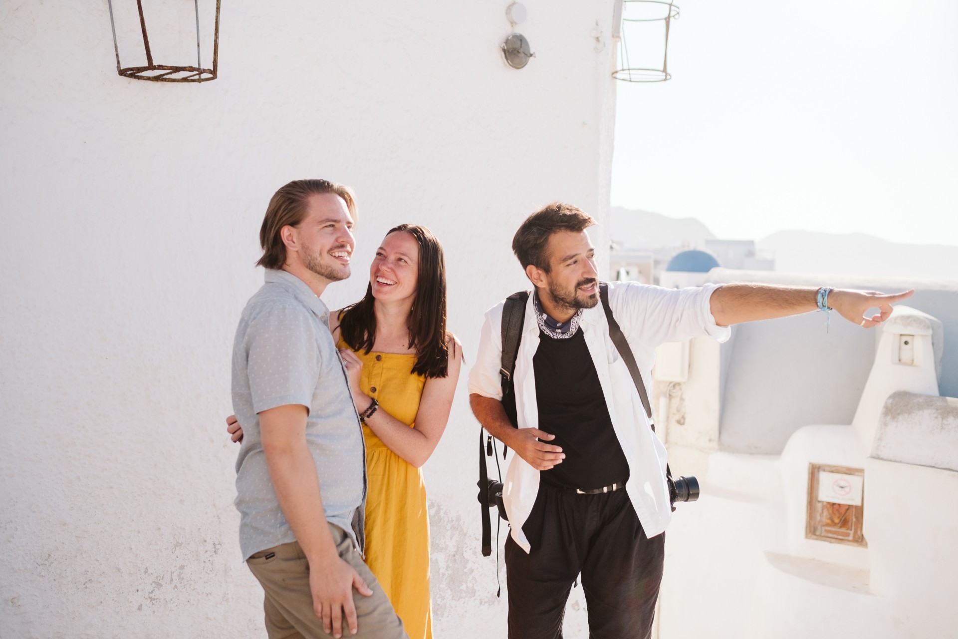 A Flytographer photographer shows his clients his hometown of Santorini during their Flytographer shoot