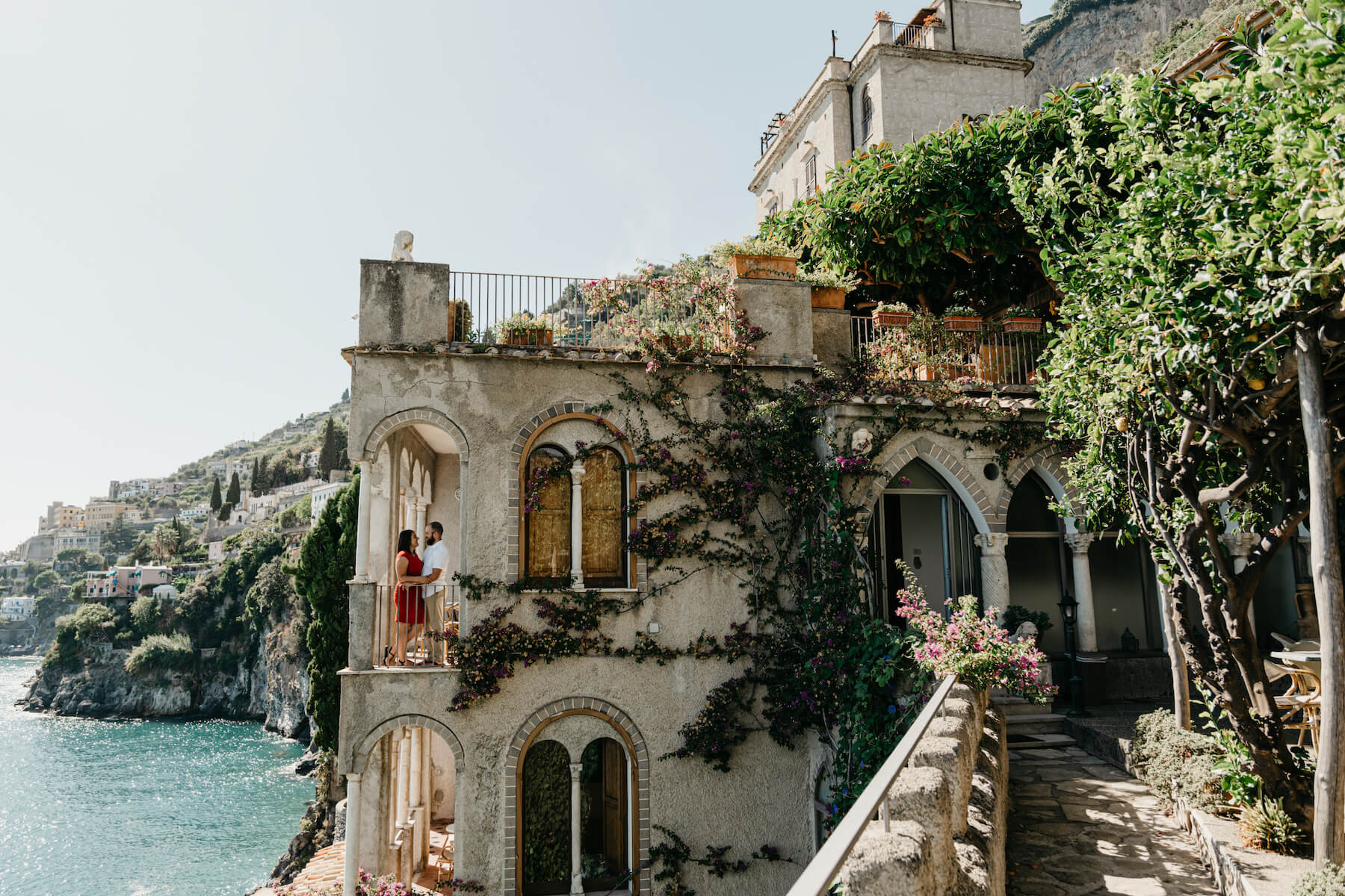 A couple standing on a patio on the amalfi coast on a couple photoshoot with Flytographer