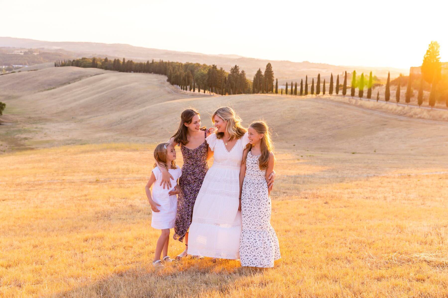 A mom and her daughters hugging in Tuscany Italy on a family photoshoot with Flytographer