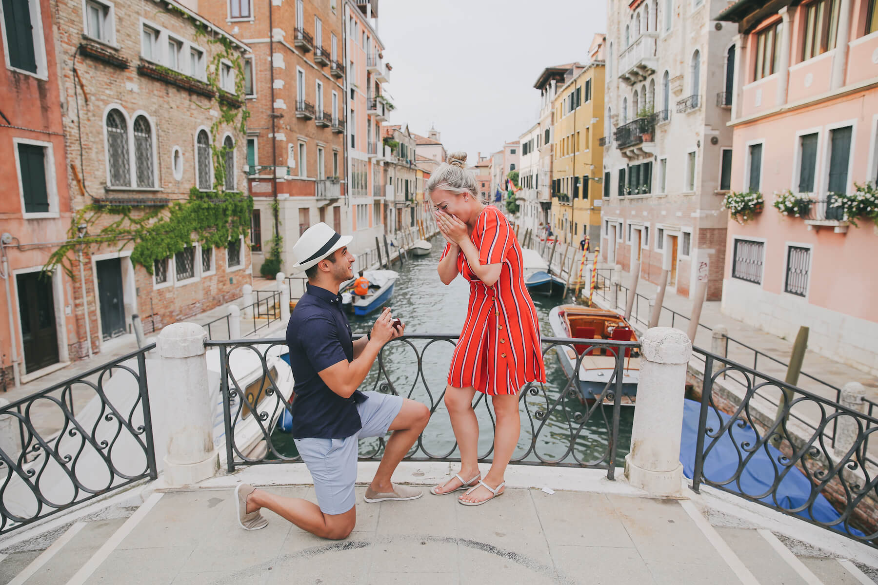 A couple getting engaged in Venice on a bridge over a canal on a surprise proposal photoshoot with Flytographer