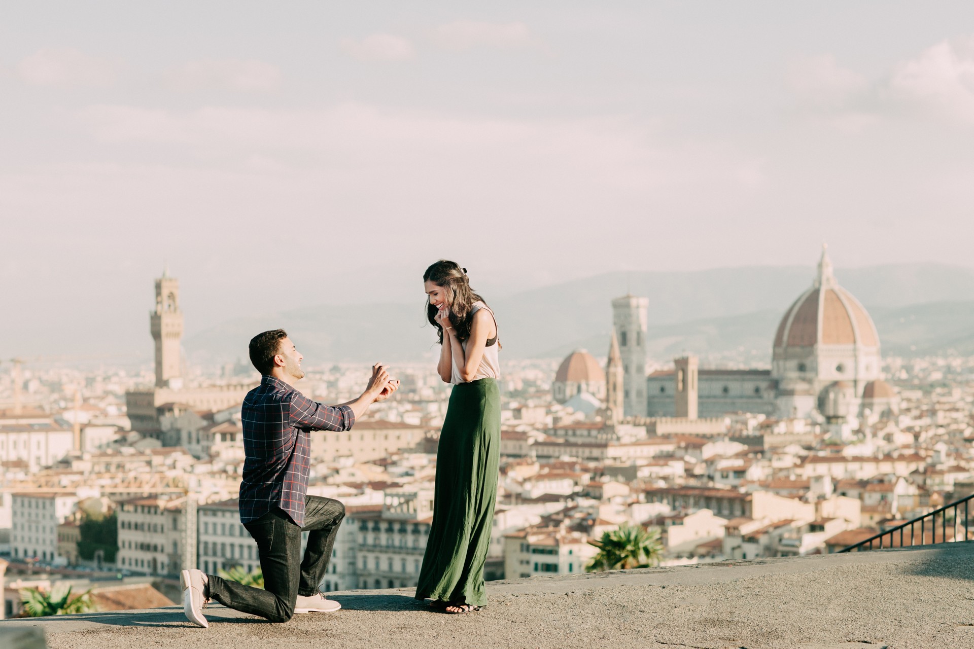 A man proposes to his girlfriend overlooking iconic views of Florence, Italy on a romantic trip