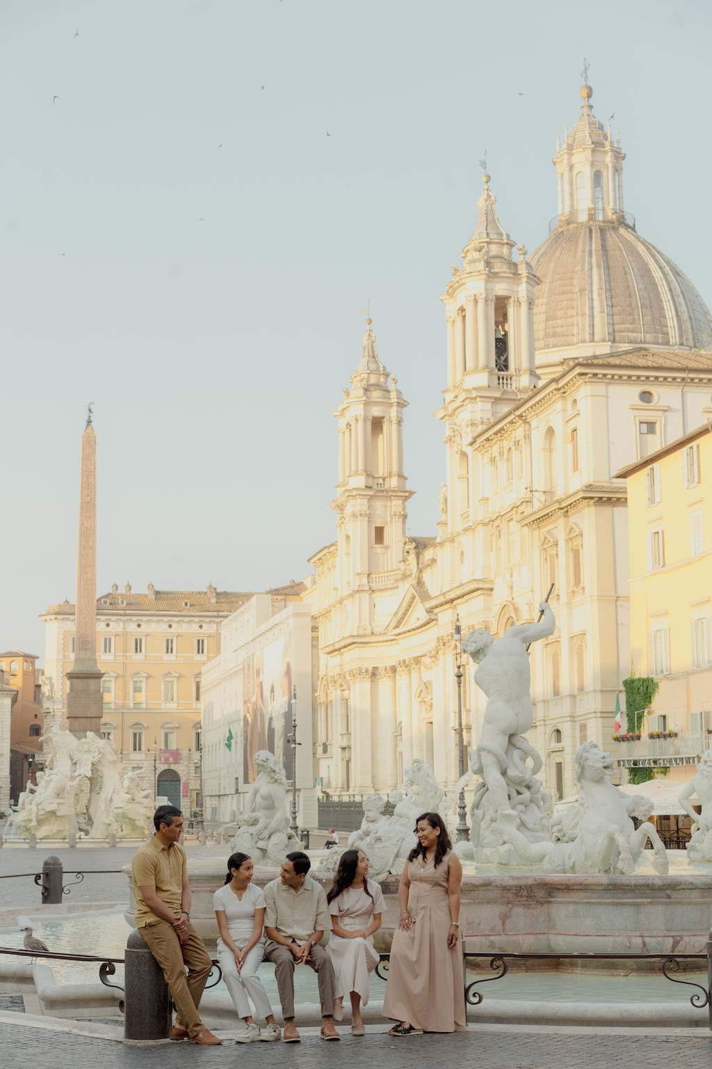 A happy family enjoys a moment amongst the regal architecture of Rome on their Flytographer photoshoot.
