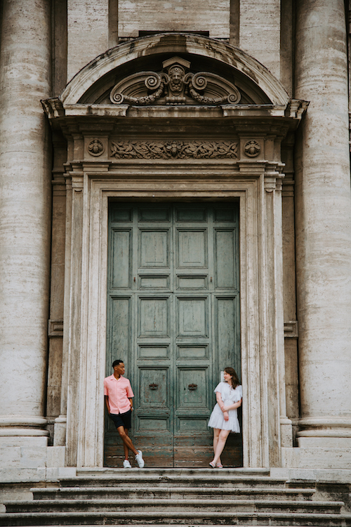 A couple leans against an epic doorway in Rome on their Flytographer photoshoot.