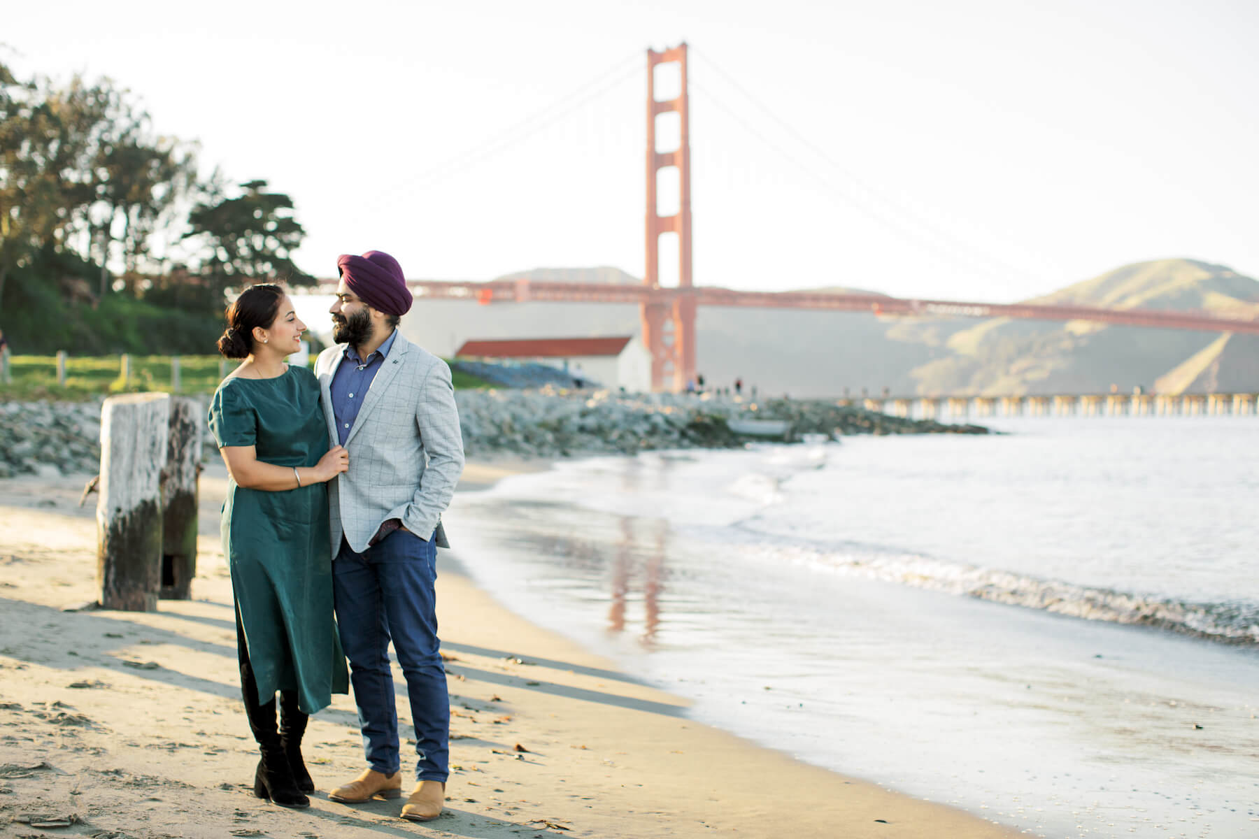 A couple hugs at Crissy Field in San Francisco in front of the Golden Gate Bridge