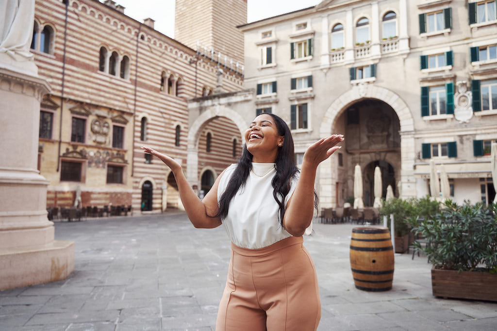 A solo traveller closes her eyes and experiences the joy of being in Verona on her Flytographer photoshoot.